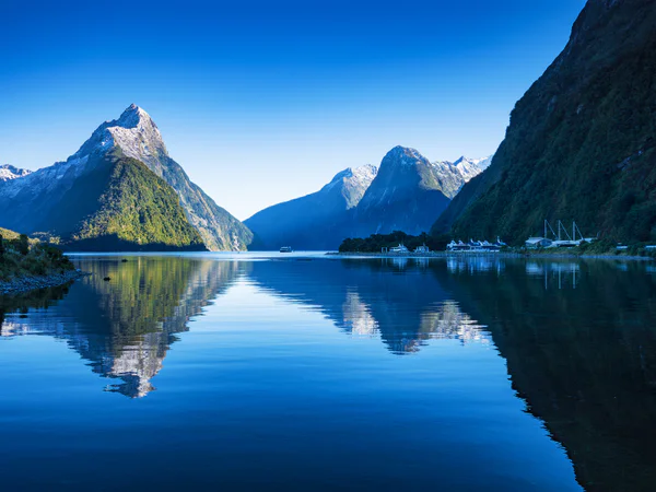 Klar, blå himmel ved Milford Sound i New Zealand