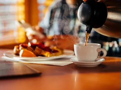 Mand sidder på diner og spiser vafler og drikker kaffe