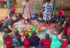 Pernille leger med lego sammen med børnene i Moshi Kids Center