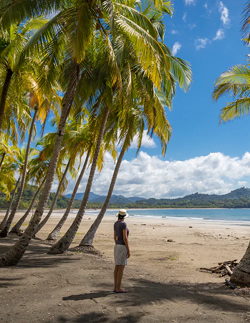 Kvinde står og nyder udsigten over vandet ved Playa Samara
