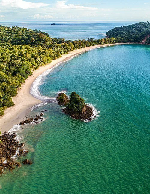 Luftfoto af den tropiske Espadilla-strand og kysten ved Manuel Antonio Nationalpark