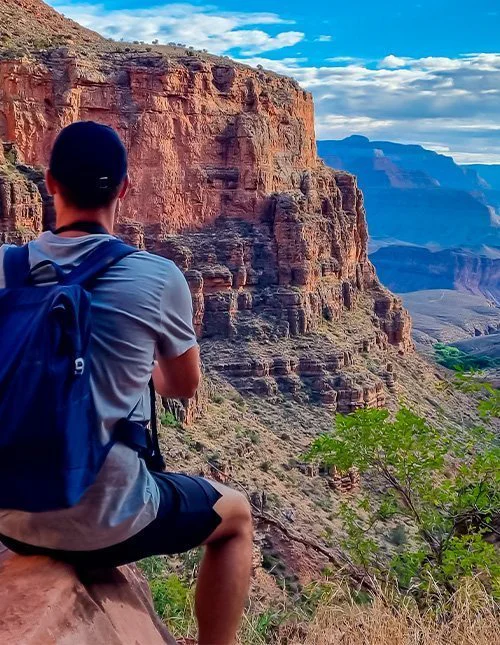 Mand på en klippe langs Bright Angel-stien med udsigt over South Rim i Grand Canyon National Park